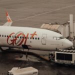 GOL Airlines aircraft connected to jet bridge at a wet airport terminal.