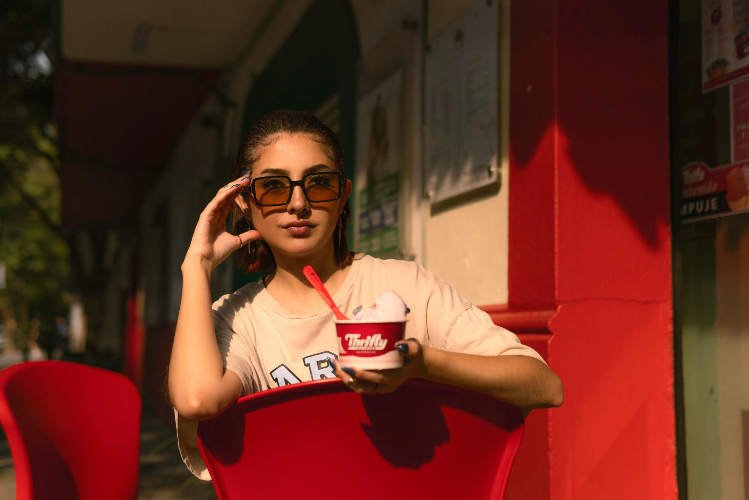 A fashionable woman enjoying ice cream in the sunny streets of Ciudad de México.