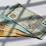 Various Brazilian real banknotes in sunlight, showcasing currency variety.