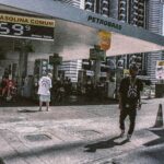 Stylish youth at a Petrobras gas station in a bustling urban setting.