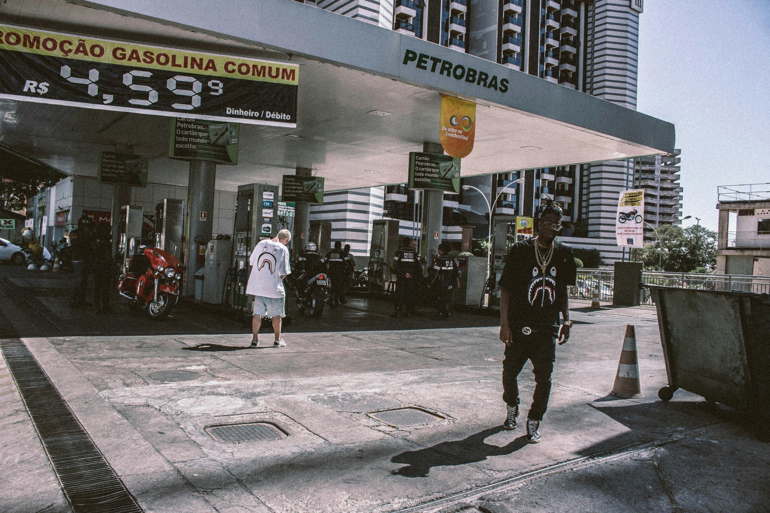 Stylish youth at a Petrobras gas station in a bustling urban setting.